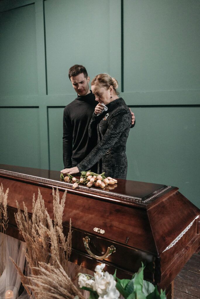 A touching moment between family members at a funeral, expressing sorrow and loss.